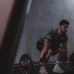 Man lifting weights in gym, displaying strength and focus. Ideal for fitness and training themes.